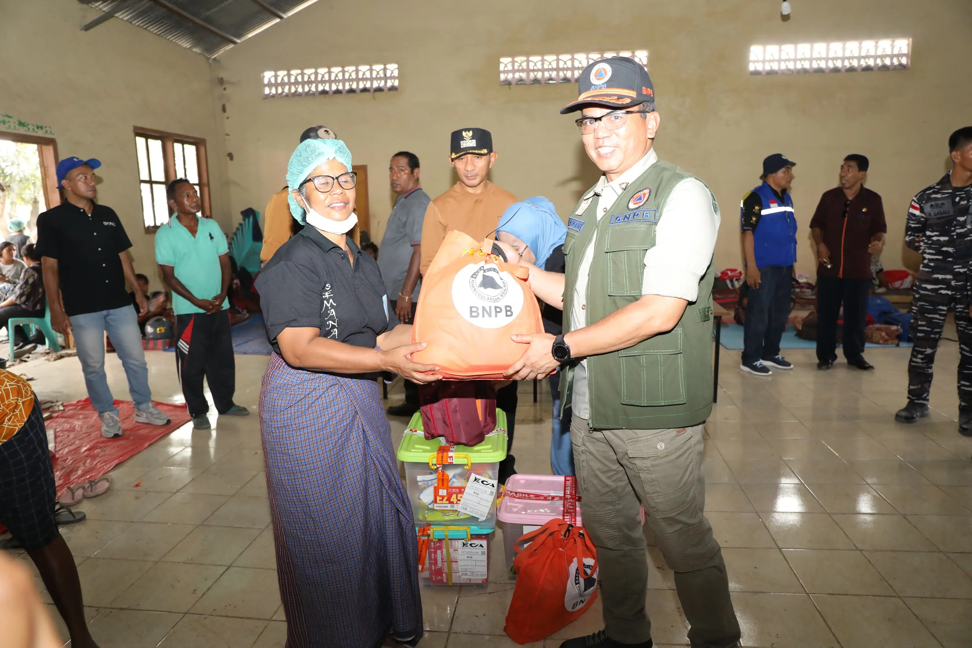 Deputi Bidang Penanganan Darurat BNPB Mayjen TNI Lukmansyah (rompi hijau) saat menyerahkan bantuan kepada warga di pos pengungsian Desa Kringa, Kabupaten Sikka, Nusa Tenggara Timur pada Kamis (7/11).